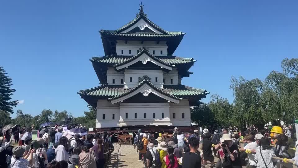 Voluntários puxam a torre do Castelo de Hirosaki com cordas