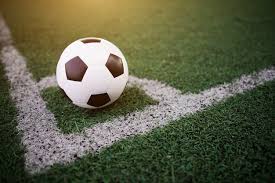 Bola de futebol sobre a marcação de escanteio em gramado sintético