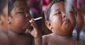 Criança segura cigarro na boca e exala fumaça em close-up