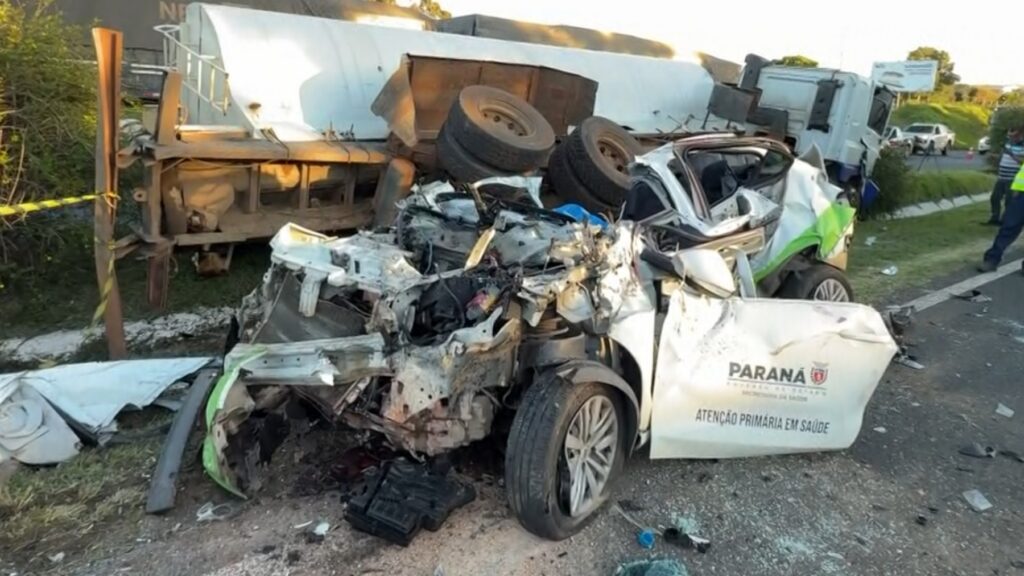 Carro com inscrição de saúde destruído após colisão com caminhão em rodovia