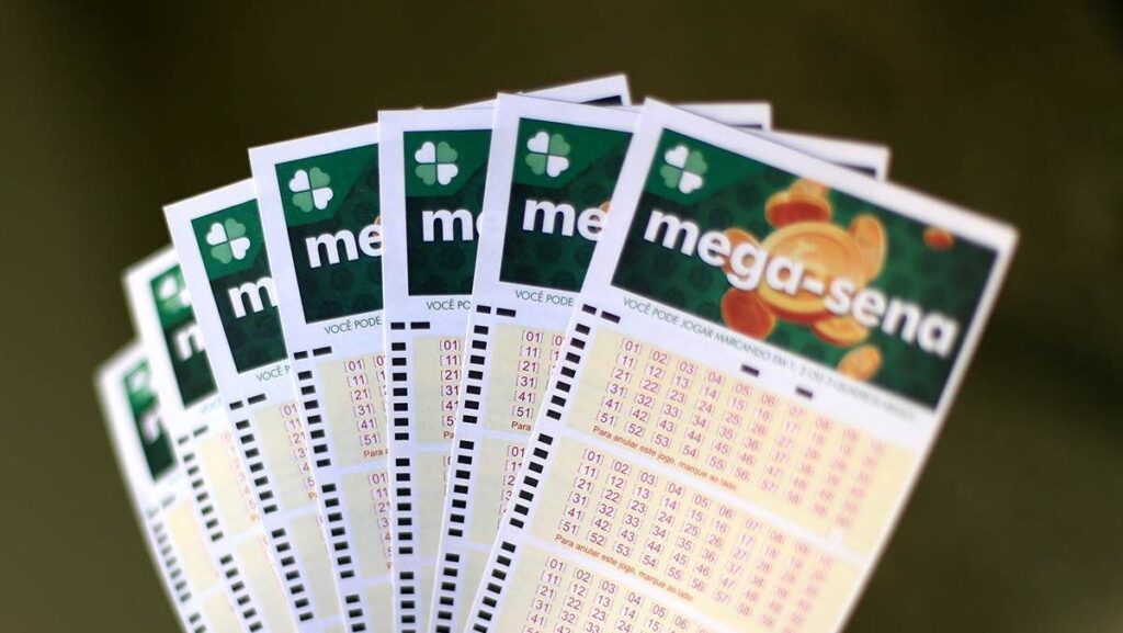 Vários volantes da Mega-Sena dispostos em abanico sobre fundo escuro