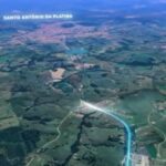 Vista aérea de uma rodovia em meio a paisagem rural com campos e áreas verdes, com texto indicando Santo Antônio da Platina