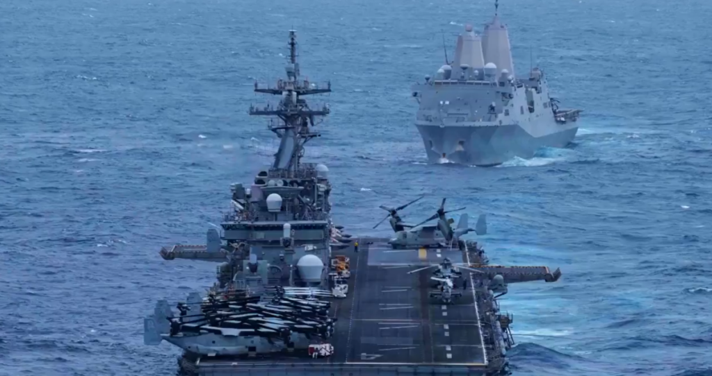 Navios militares navegando em águas abertas com helicópteros no convés