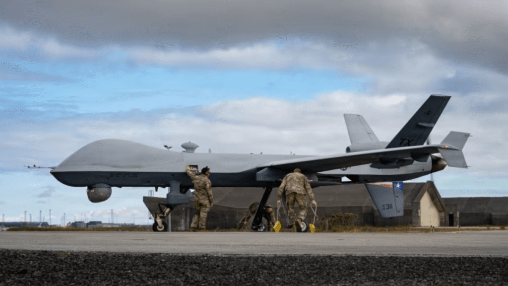 Um drone MQ-9 é preparado por militares em pista de aeroporto sob céu nublado