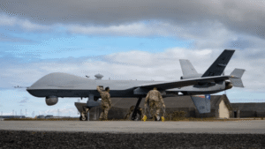 Um drone MQ-9 é preparado por militares em pista de aeroporto sob céu nublado