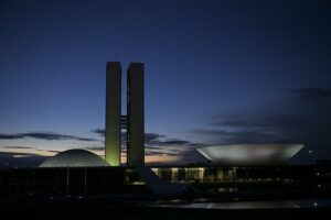 Edifícios do poder legislativo iluminados ao entardecer em Brasília