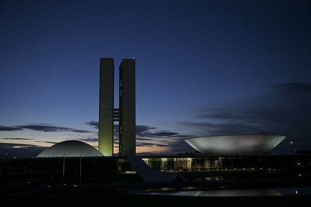 Edifícios do poder legislativo iluminados ao entardecer em Brasília