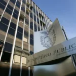 Fachada de prédio com placa do Ministério Público do Estado do Paraná sob céu claro