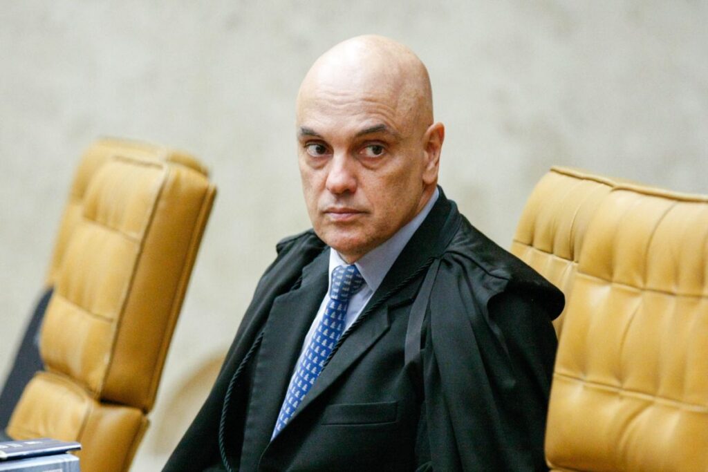 Um homem de toga sentado em cadeira de couro em ambiente formal