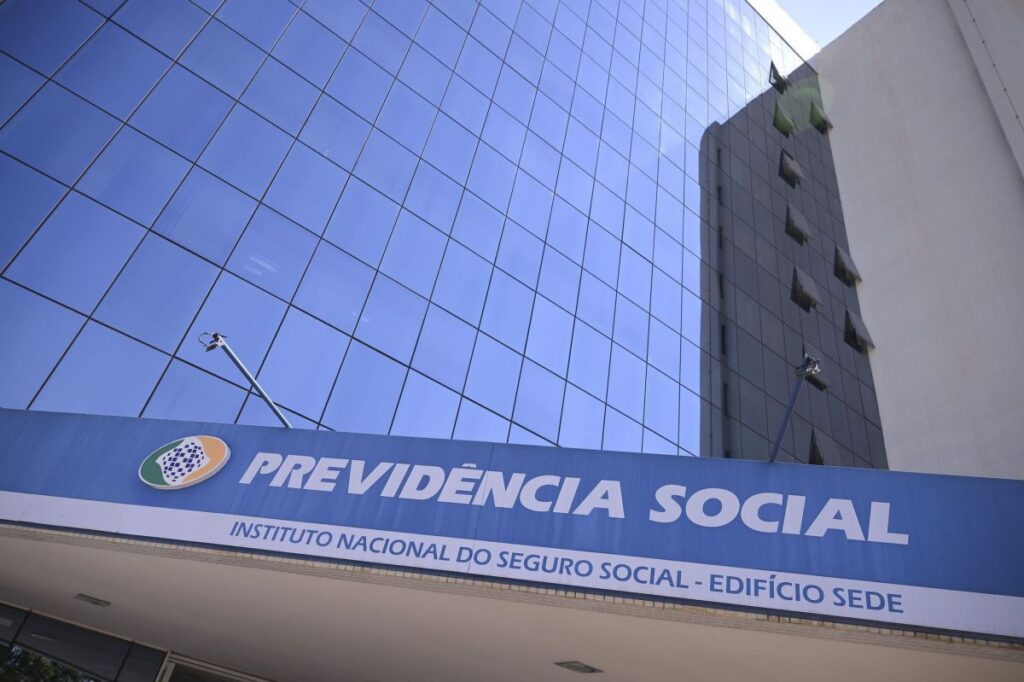 Fachada de prédio com placa da Previdência Social e edifício sede do Instituto Nacional do Seguro Social