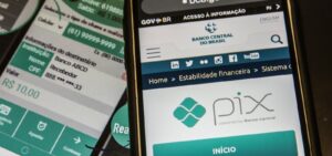 Dois celulares exibem telas com o sistema Pix e informações de transferência financeira
