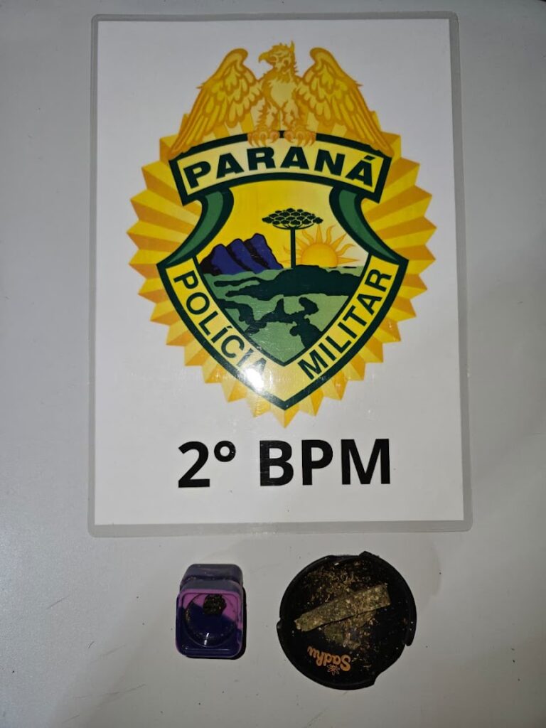 Objetos apreendidos em frente ao brasão da Polícia Militar do Paraná, com inscrição 2º BPM