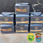 Sete baterias empilhadas em frente a parede, com logotipos de marcas e emblemas da Polícia Militar do Paraná