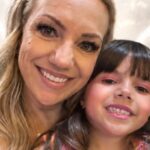 Uma mulher e uma criança sorrindo com asas de anjo em um fundo claro