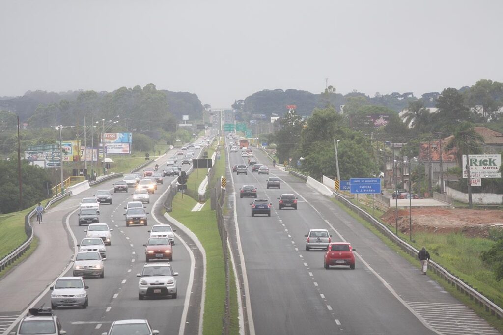 Tráfego intenso em rodovia com diversos veículos circulando em ambos os sentidos