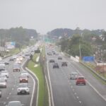 Tráfego intenso em rodovia com diversos veículos circulando em ambos os sentidos