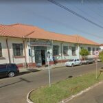 Fachada de um prédio com placa de Misericórdia de Jacarezinho, veículos estacionados na rua ao lado