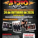 Um grupo de pessoas posa em frente a um palco com instrumentos musicais em um evento de rock ao ar livre