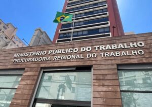 Edifício com placa do Ministério Público do Trabalho e bandeira do Brasil acima da entrada principal
