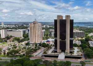 Um grupo de edifícios altos em uma área urbana com vegetação e trânsito ao redor