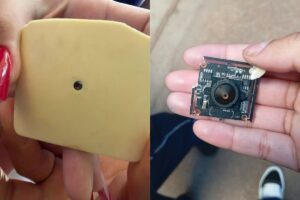 Um objeto com lente escondido em parede e um circuito eletrônico com câmera em mão