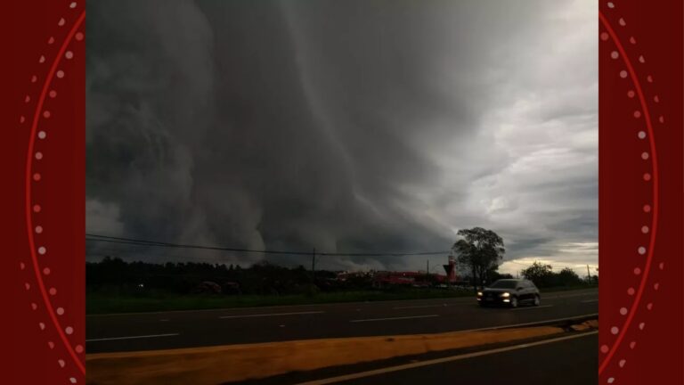 Nuvens escuras e densas sobre rodovia com veículo circulando em meio a tempestade