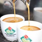 Café sendo servido em xícaras com logotipo de Indicação de Procedência do Norte Pioneiro do Paraná