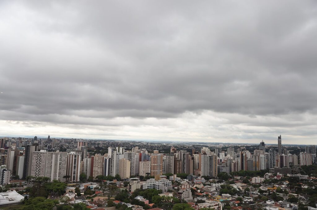 Uma cidade grande sob um céu nublado e cinzento com edifícios altos e residenciais em primeiro plano