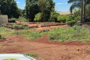 Um terreno com fundações de construção e fita de isolamento em área verde