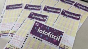 Várias folhas de apostas da Lotofácil espalhadas sobre uma superfície plana
