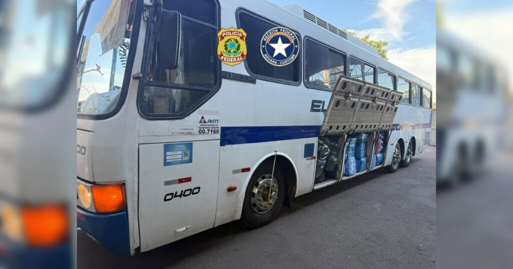 Um ônibus com portas abertas e sacos apreendidos em sua lateral