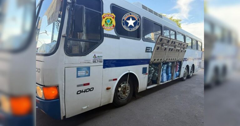 Um ônibus com portas abertas e sacos apreendidos em sua lateral