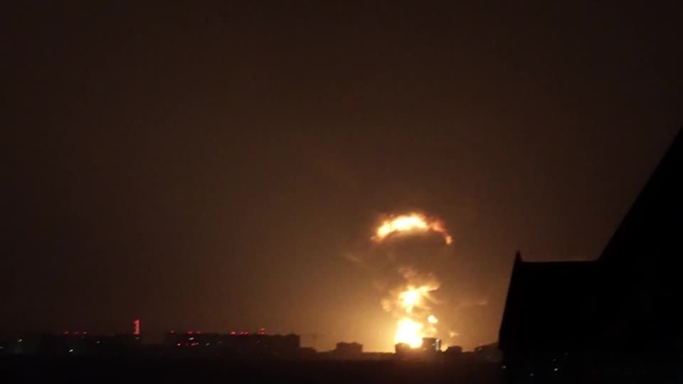 Explosão ilumina o céu noturno sobre um conjunto de edifícios em área urbana