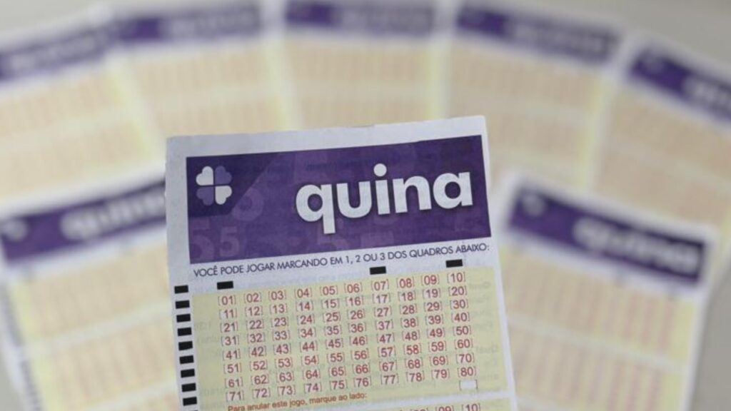 Um bilhete da loteria Quina em destaque com outros bilhetes ao fundo