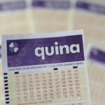 Um bilhete da loteria Quina em destaque com outros bilhetes ao fundo