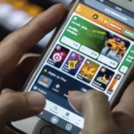 Um homem opera um smartphone com aplicativo de apostas esportivas na tela
