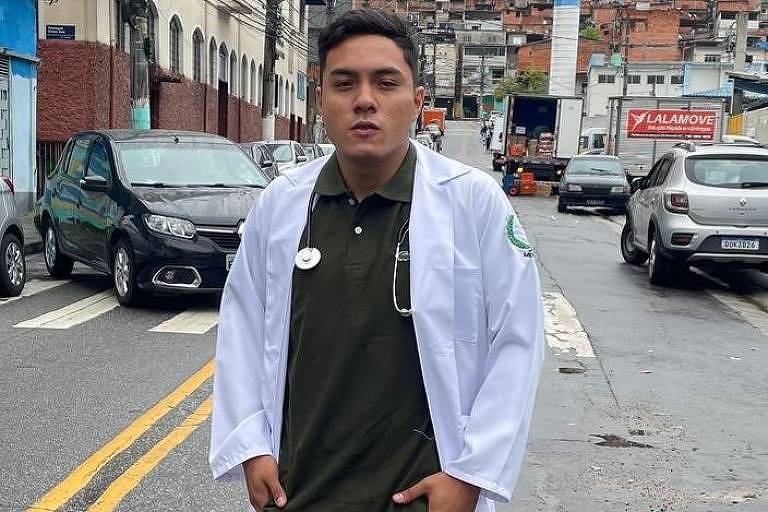 Um homem de jaleco branco em uma rua movimentada com carros e prédios ao fundo