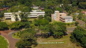 Um complexo de edifícios universitários cercado por árvores e gramados com uma estrada curva ao redor