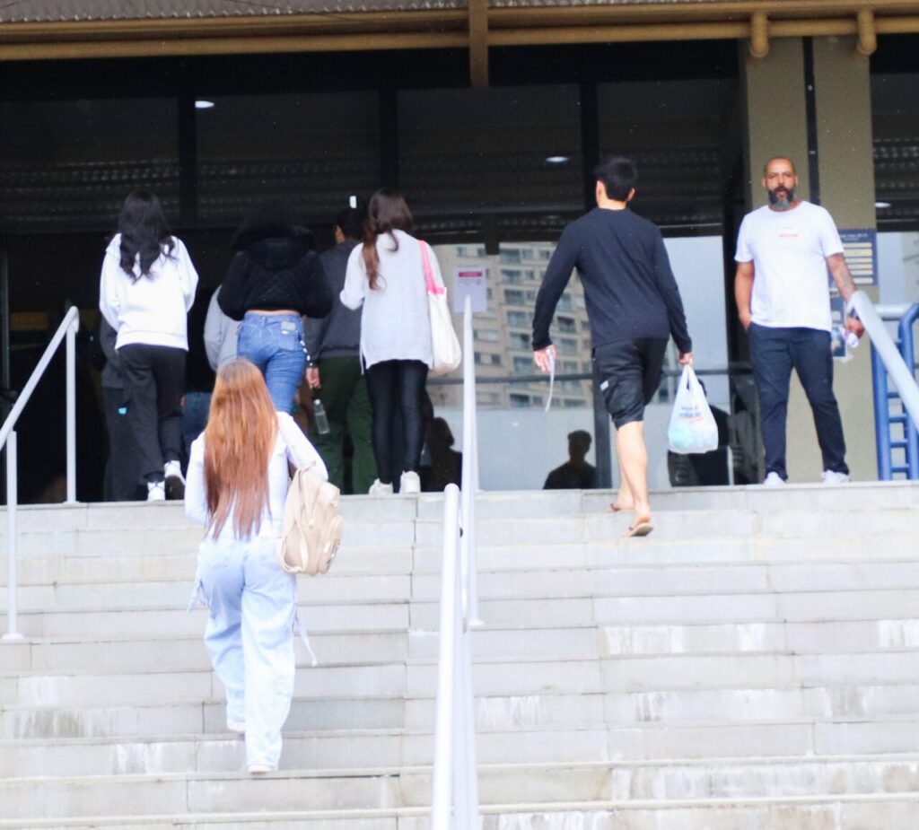 Um grupo de pessoas sobe as escadas de um prédio público durante o dia
