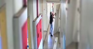 Um homem de terno e uma mulher em um corredor de edifício abrindo porta